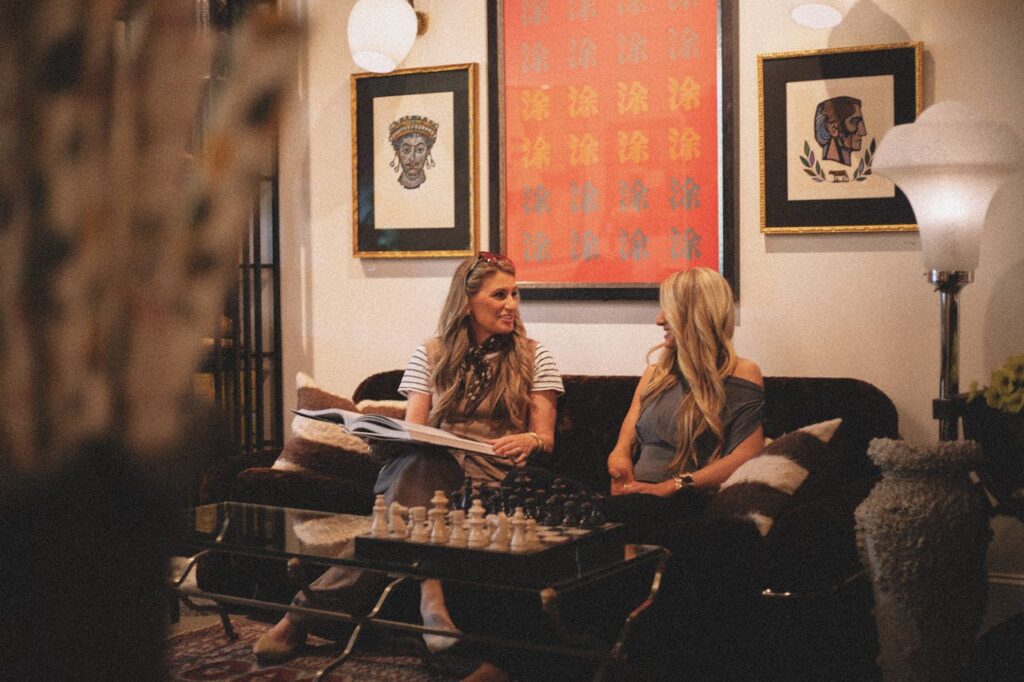 Two women chat in a chic, cozy boutique showcasing artistic decor in Greenville, SC.